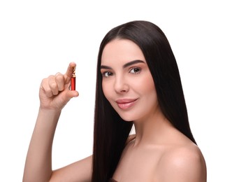 Beautiful young woman holding skincare ampoule on white background