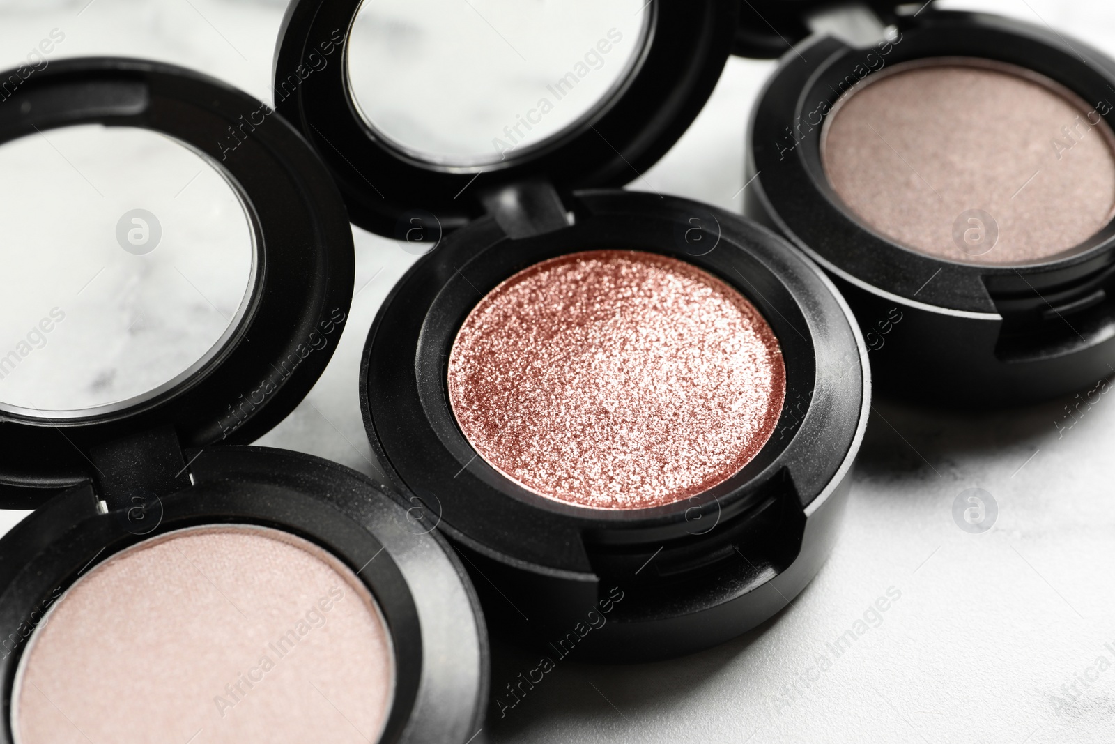 Photo of Different eye shadows on marble table, closeup