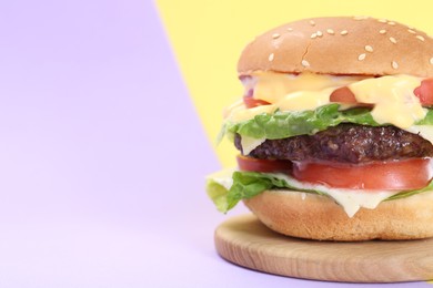 Photo of Burger with delicious patty on color background, closeup. Space for text
