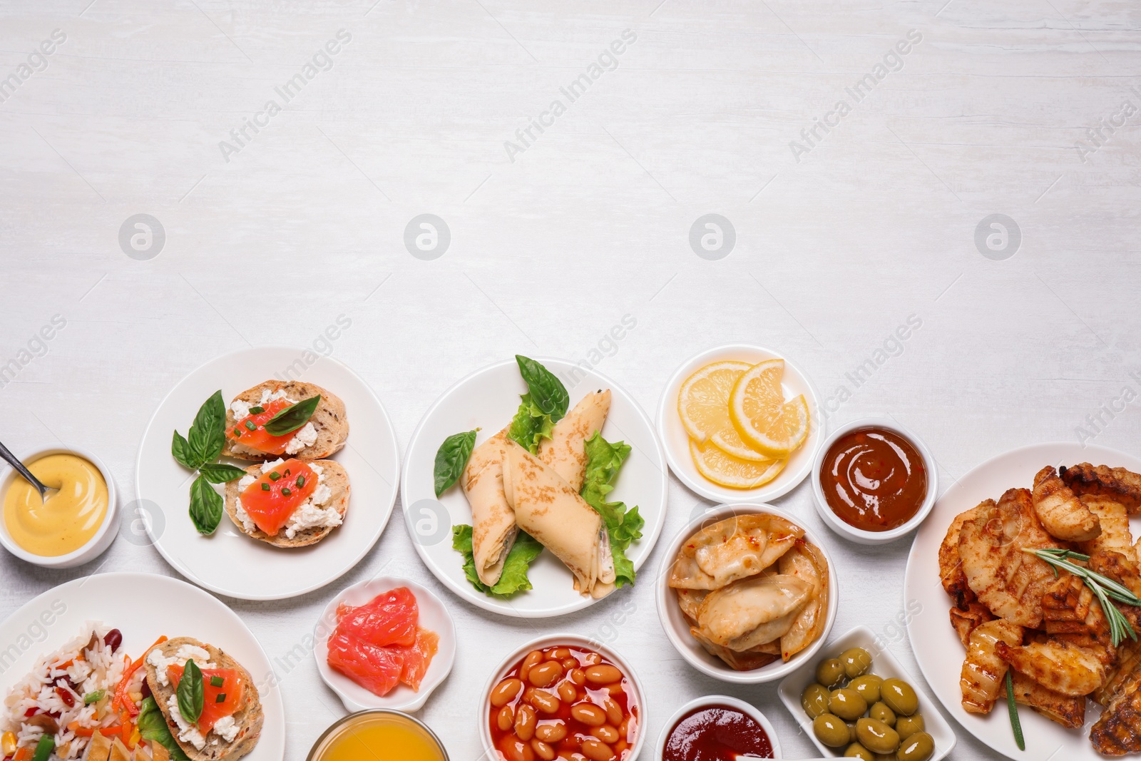 Photo of Buffet service. Flat lay composition with different dishes on white wooden table, space for text