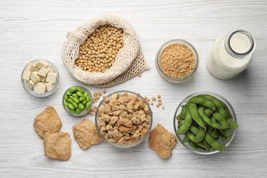 Different organic soy products on white wooden table, flat lay