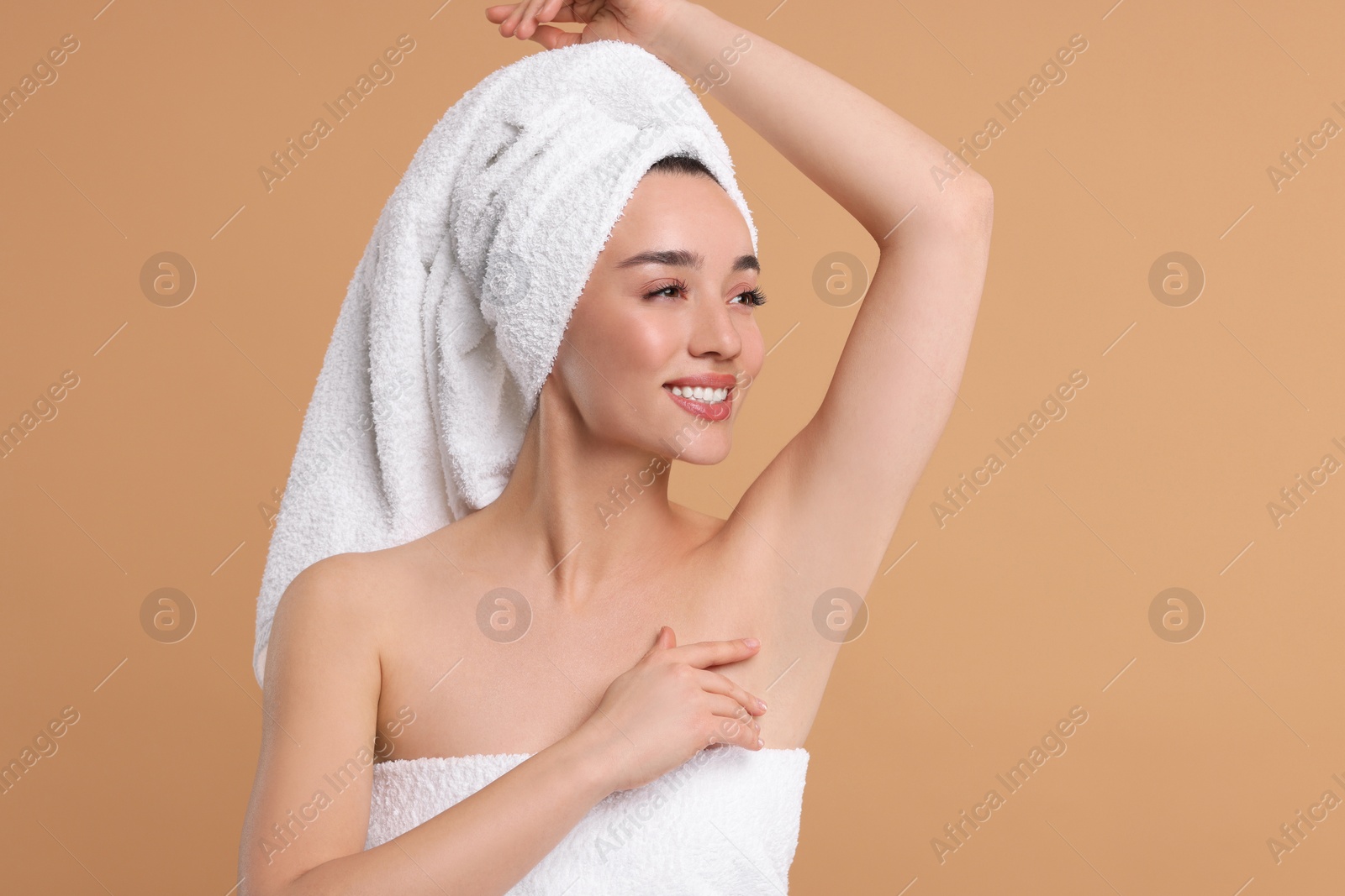 Photo of Beautiful woman showing armpit with smooth clean skin on beige background