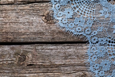 Photo of Beautiful lace on wooden table, top view. Space for text