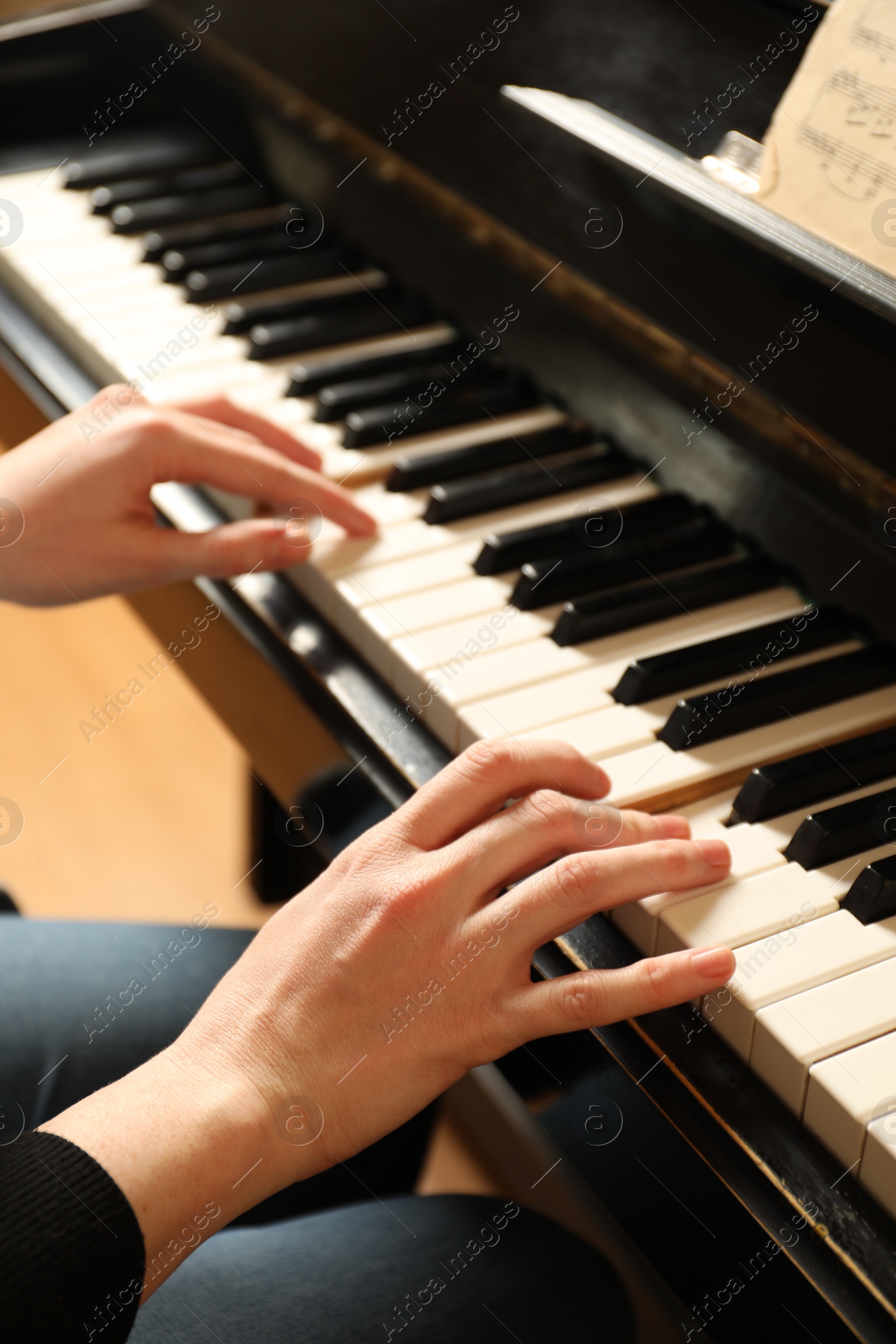 Photo of Young woman playing piano, closeup. Music lesson