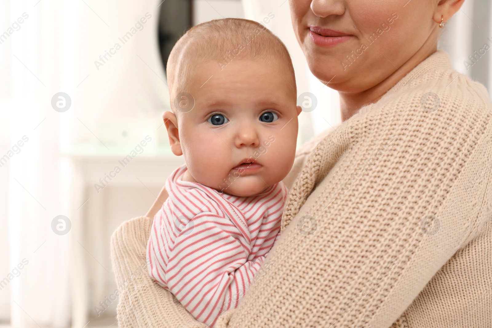 Photo of Young woman and her little baby at home, closeup