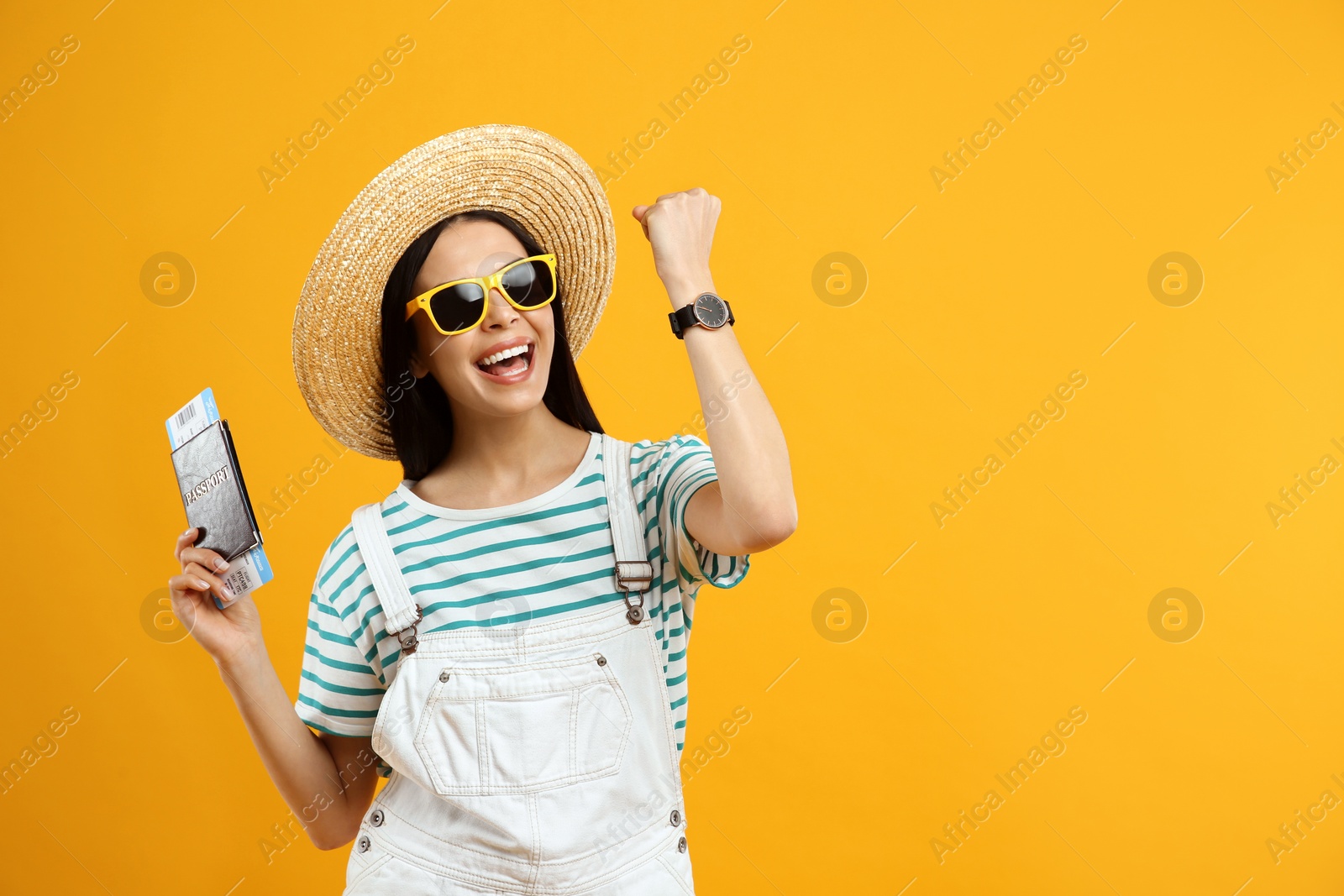 Photo of Happy female tourist with ticket and passport on yellow background. Space for text