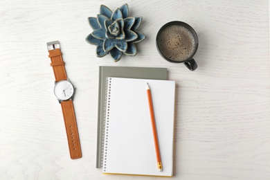 Photo of Flat lay composition with office stationery and cup of coffee on white wooden table