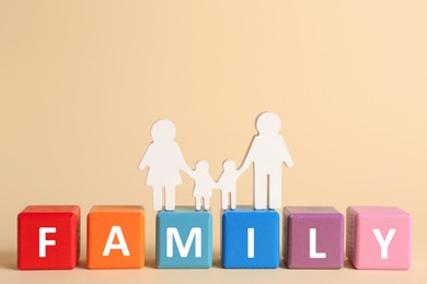 Photo of Figure and word Family made of colorful cubes with letters on pale yellow background