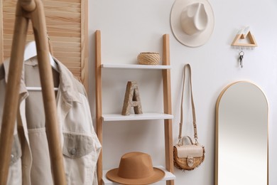 Modern hallway with stylish furniture, accessories and wooden hanger for keys on white wall. Interior design