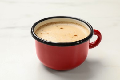 Photo of Cup of aromatic coffee on white table, closeup
