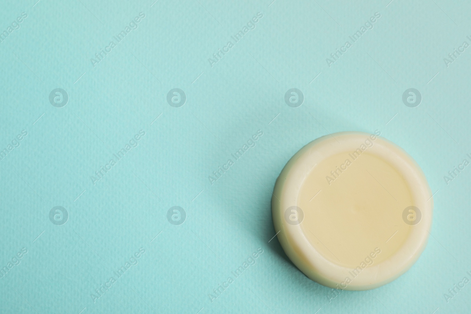 Photo of Solid shampoo bar on turquoise background, top view. Space for text