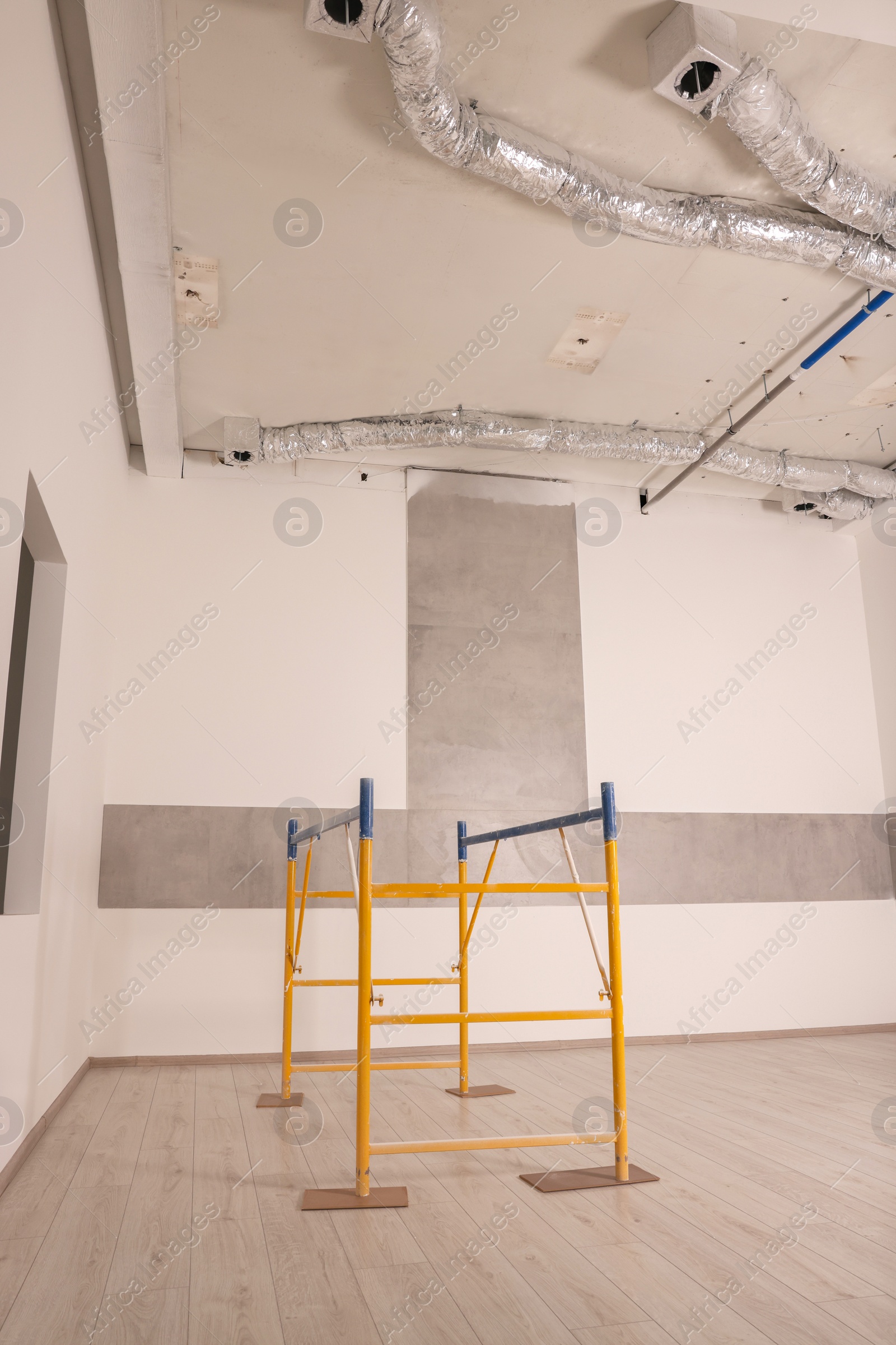 Photo of Professional construction scaffold in empty renovated room