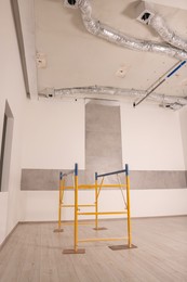 Photo of Professional construction scaffold in empty renovated room