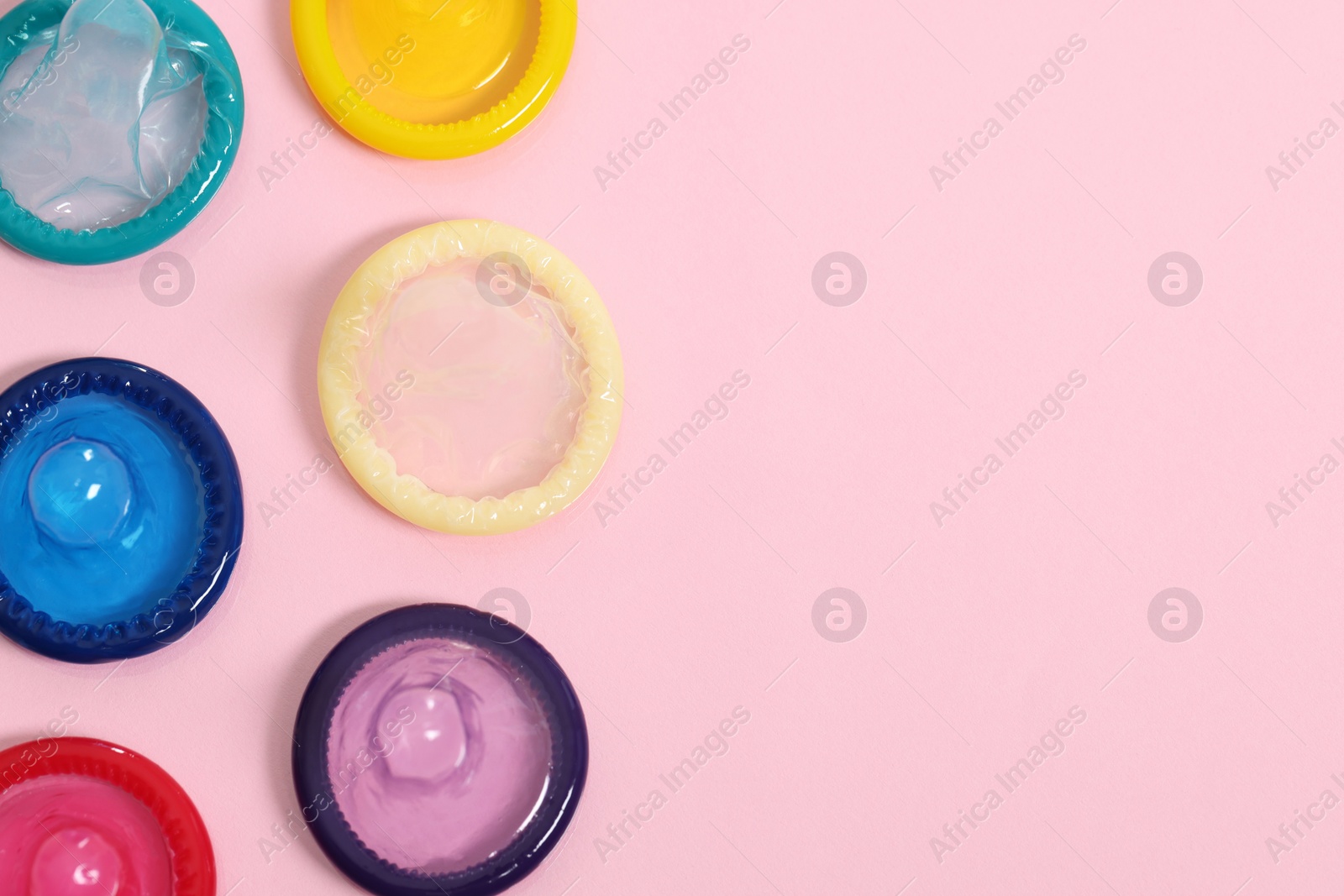 Photo of Condoms on pink background, top view with space for text. Safe sex