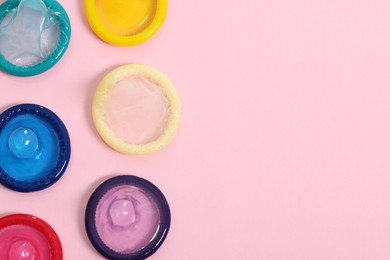 Condoms on pink background, top view with space for text. Safe sex
