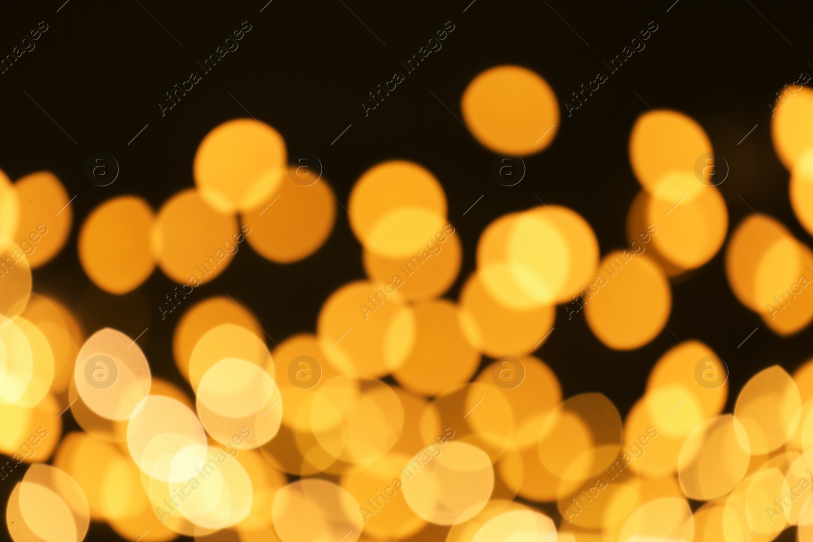 Photo of Beautiful golden lights on dark background. Bokeh effect