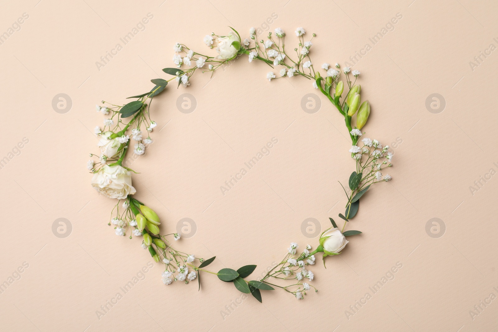 Photo of Frame made of beautiful gypsophila, roses, eucalyptus and freesia on beige background, top view. Space for text