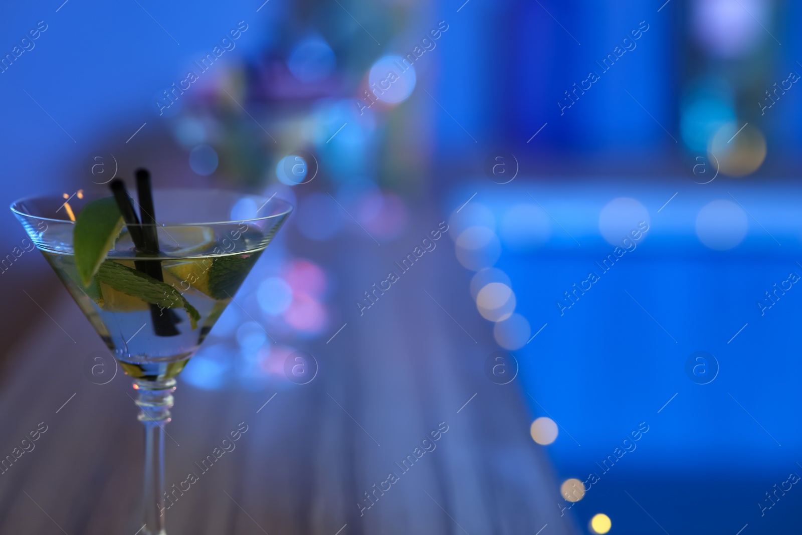 Photo of Delicious lime martini on blurred background, closeup with space for text