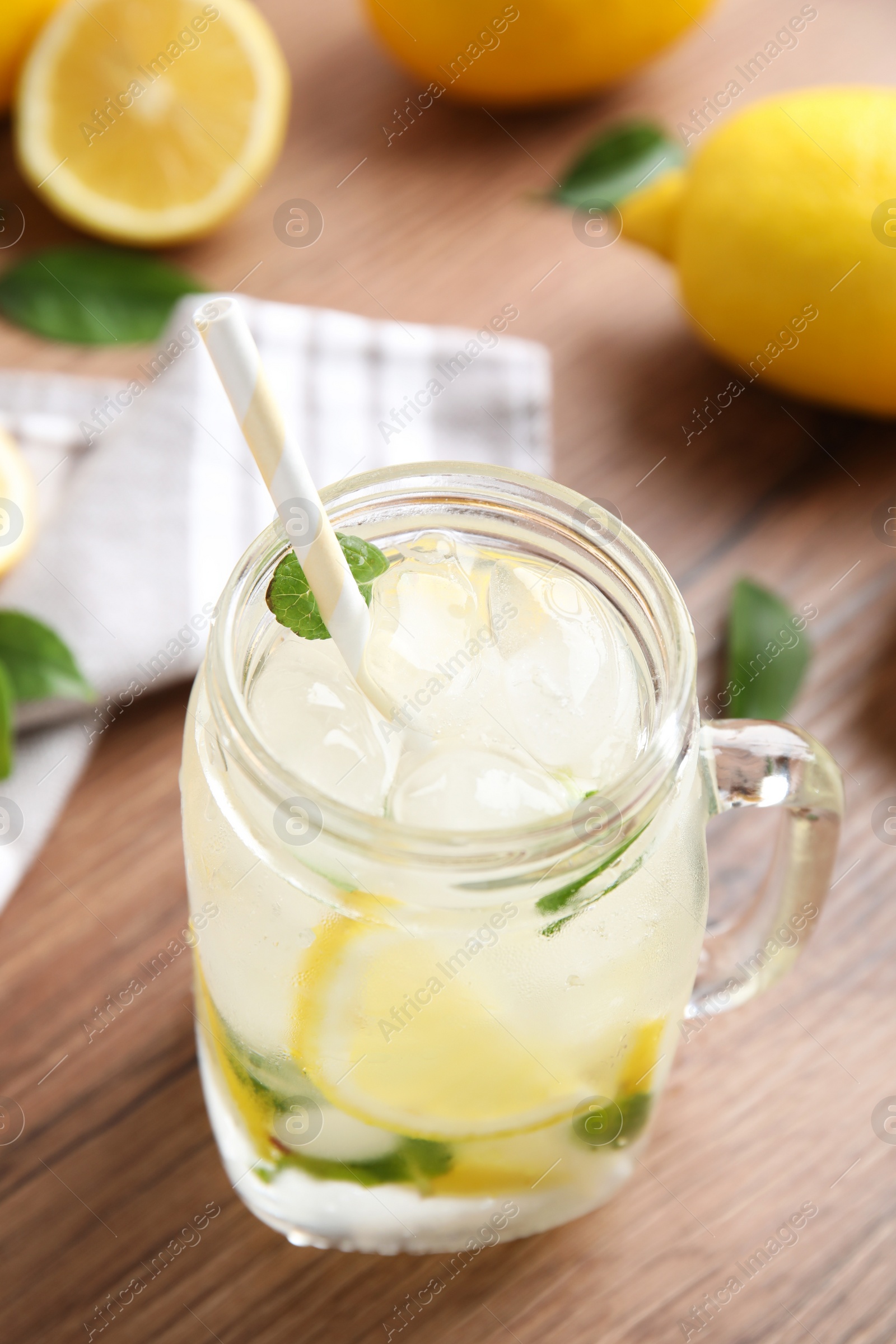 Photo of Mason jar of cold lemonade on wooden table