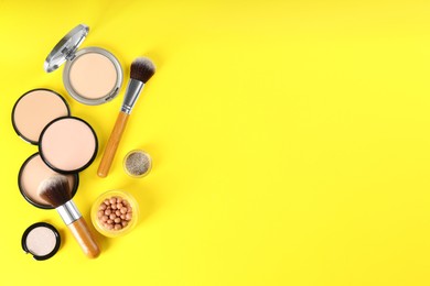 Flat lay composition with makeup brushes on yellow background, space for text