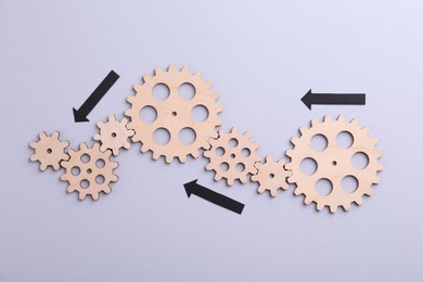 Photo of Business process organization and optimization. Scheme with wooden figures and arrows on lilac background, top view