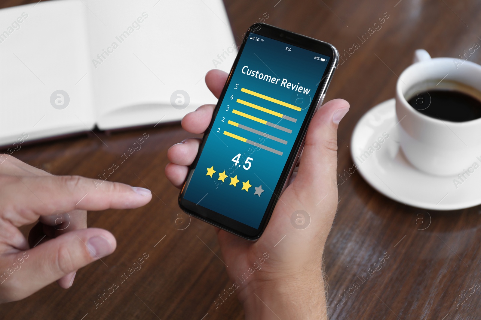 Image of Man using smartphone to give feedback at table, closeup. Customer review