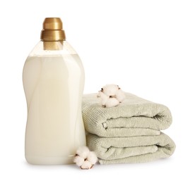 Photo of Bottle of fabric softener, stacked clean towels and fluffy cotton flowers isolated on white