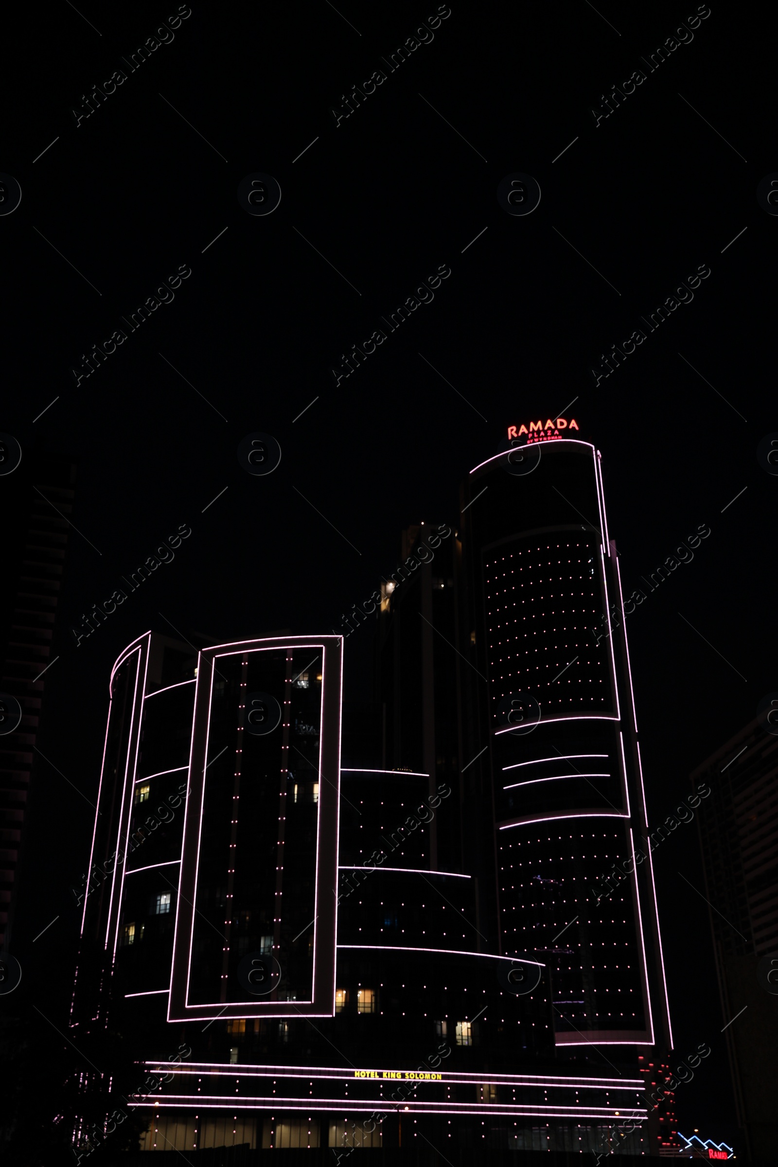 Photo of BATUMI, GEORGIA - JUNE 09, 2022: Night cityscape with illuminated building of Ramada Hotel