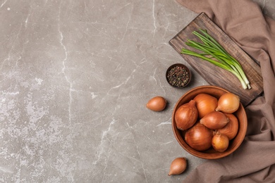 Flat lay composition with ripe onions on grey background