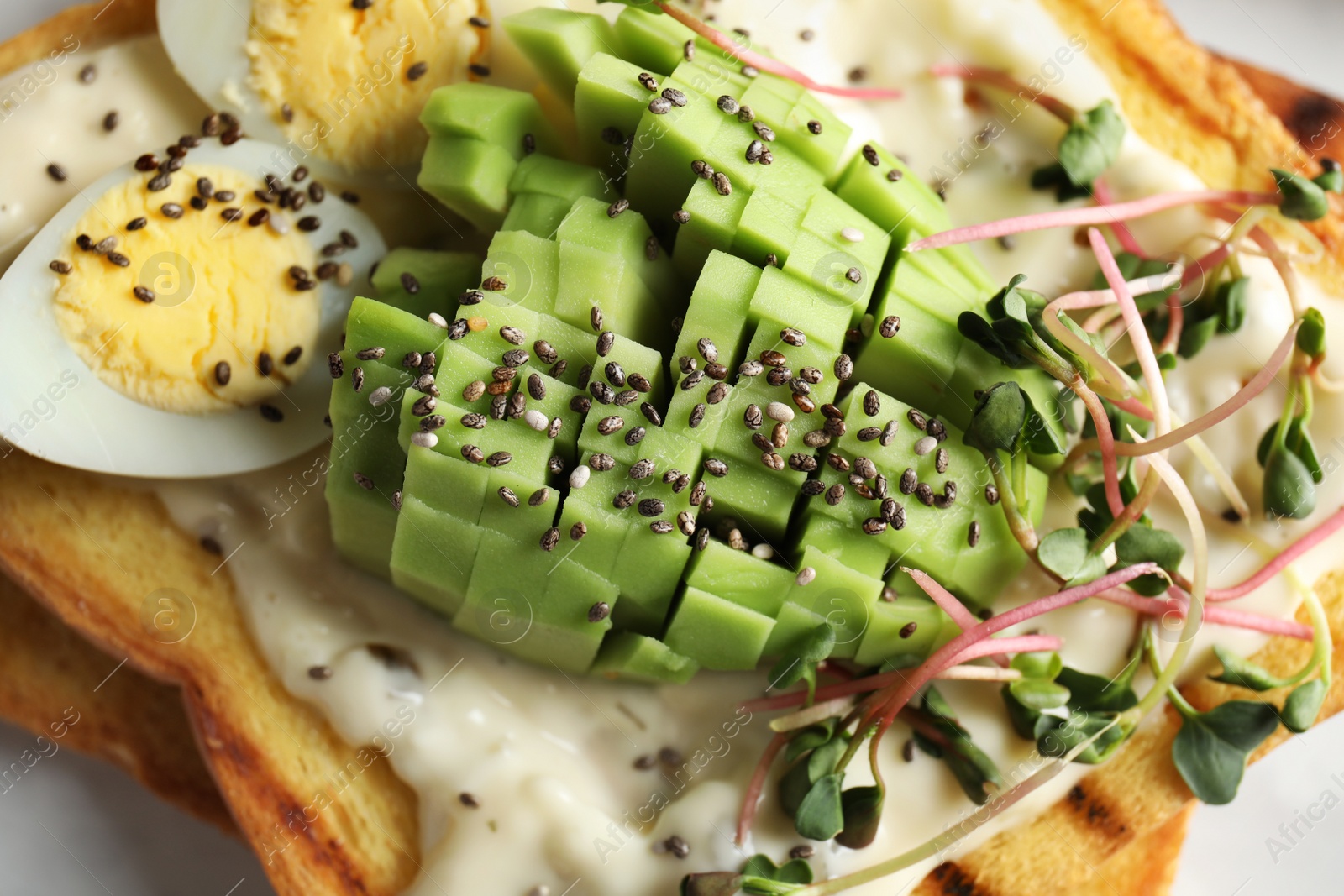 Photo of Tasty toast with avocado, sprouts and chia seeds, closeup