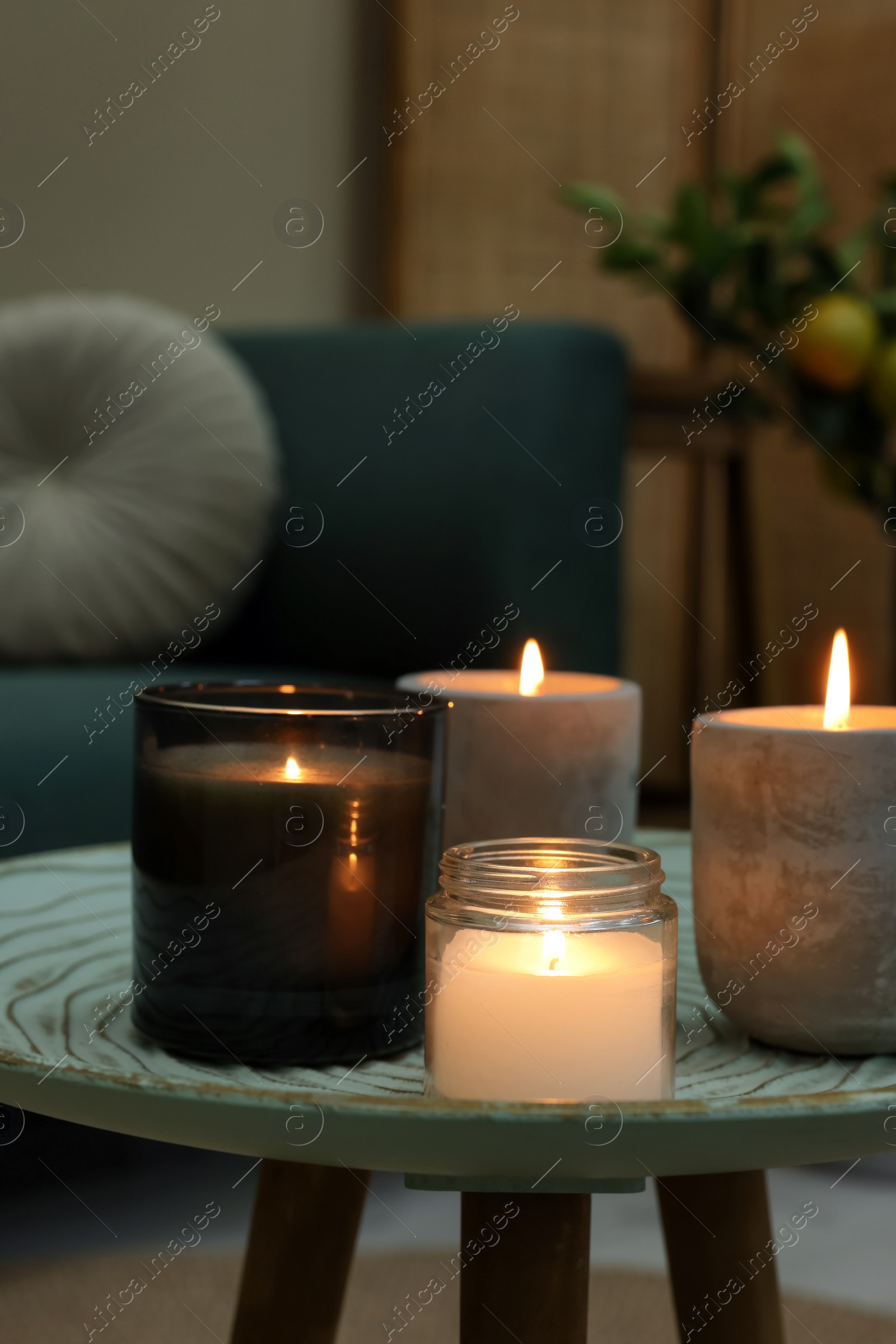 Photo of Lit candles on table in living room. Space for text