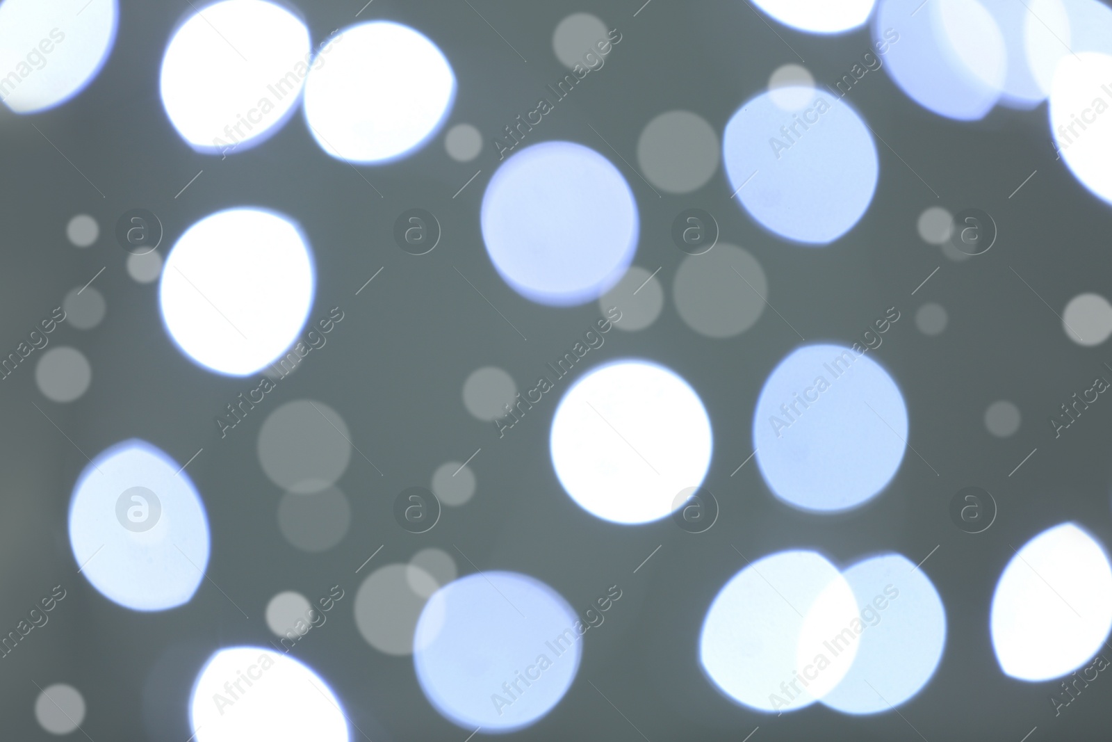 Photo of Beautiful blurred lights on grey background, bokeh effect