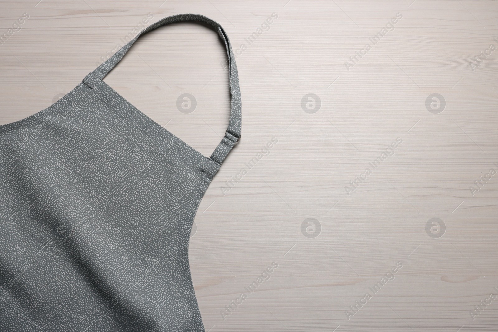 Photo of Stylish apron on white wooden table, top view. Mockup for design