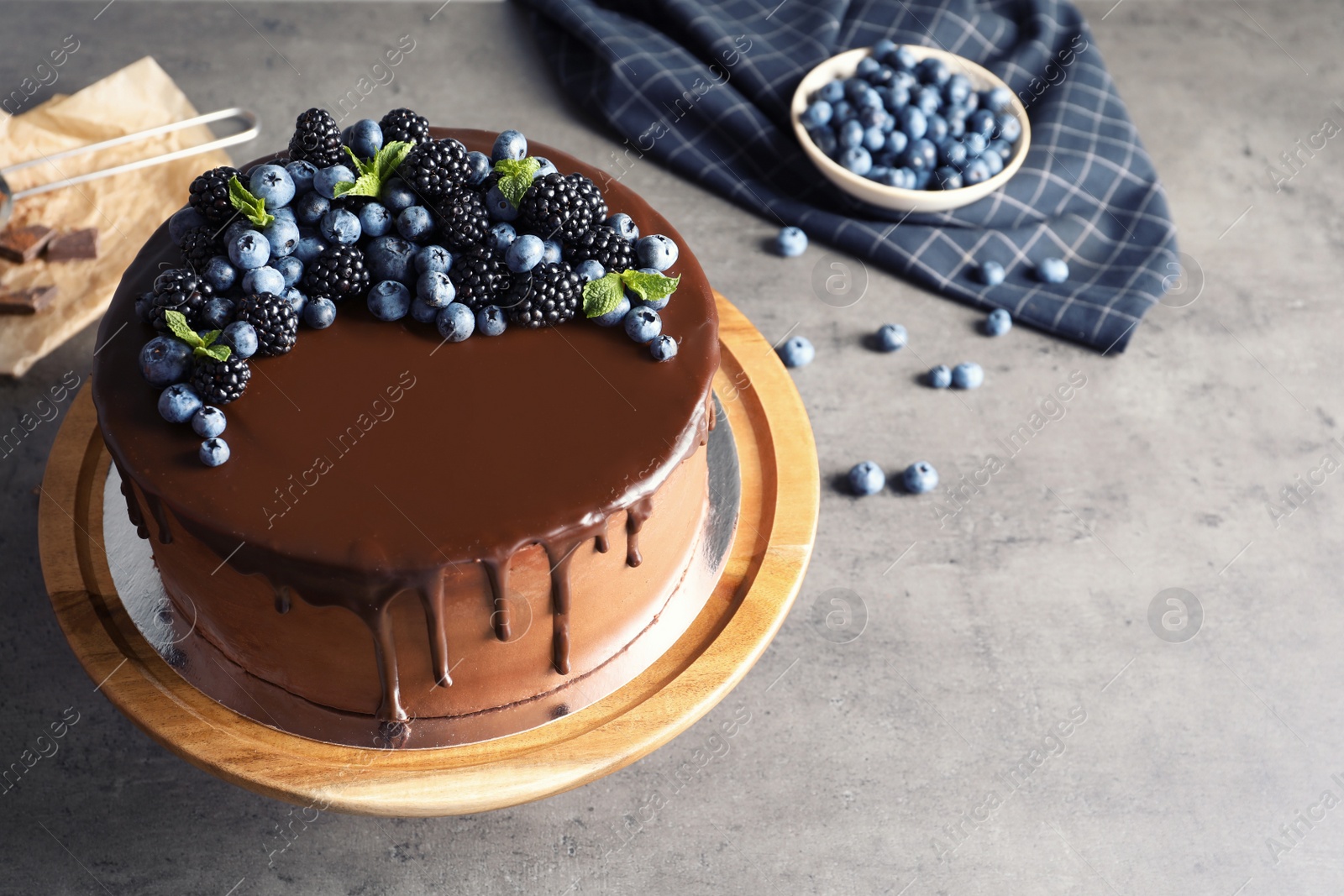 Photo of Fresh delicious homemade chocolate cake with berries on gray table. Space for text