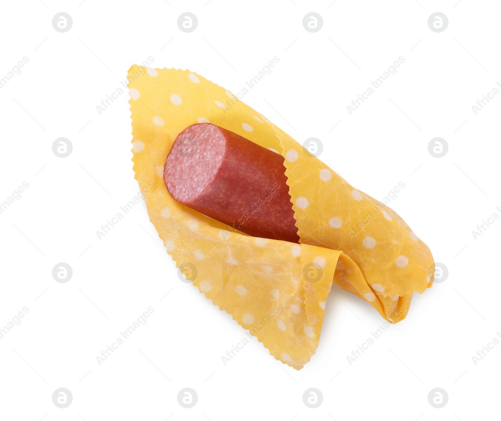 Photo of Fresh tasty sausage in beeswax food wrap isolated on white, top view