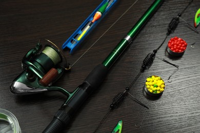 Photo of Modern fishing tackle on dark wooden background