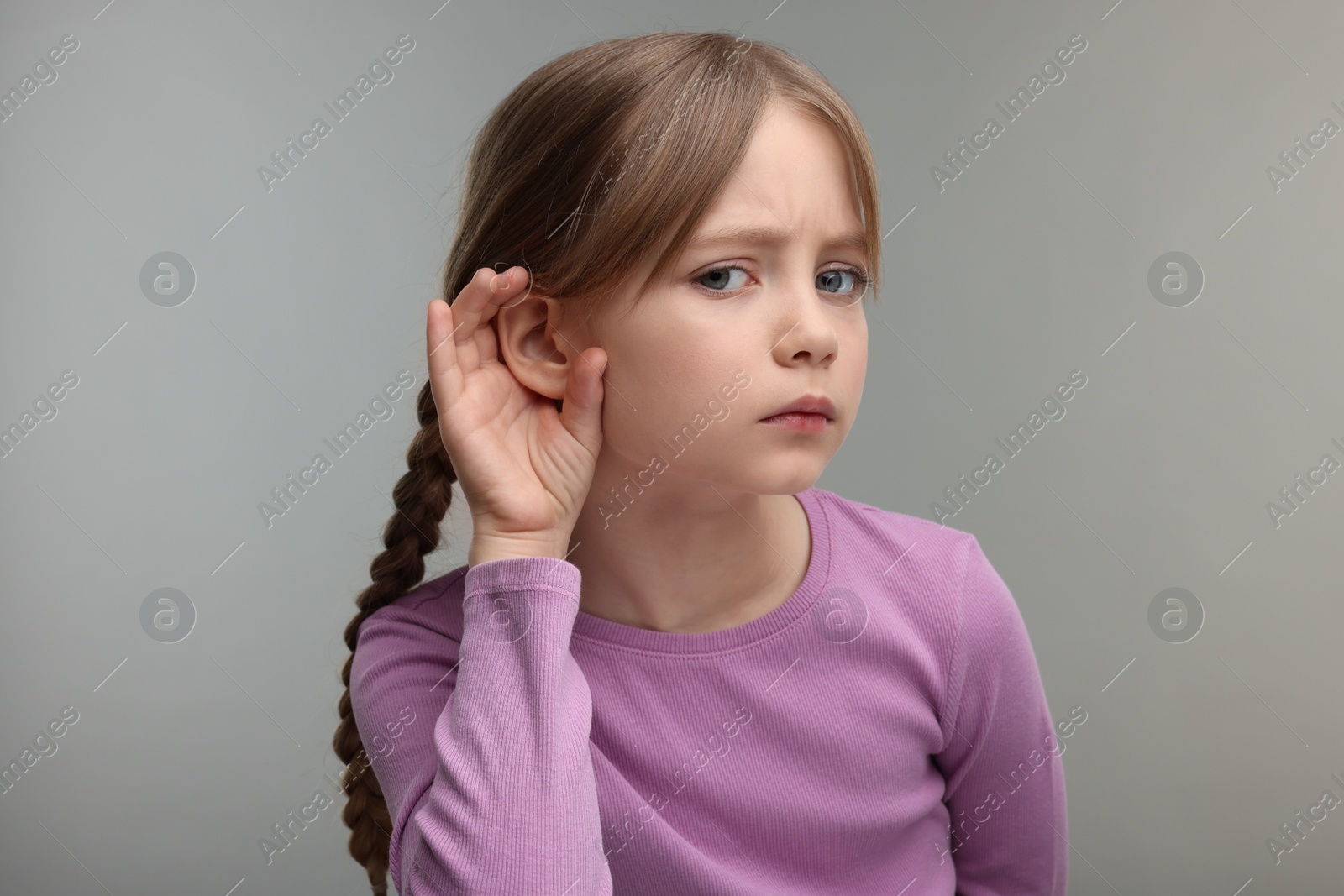 Photo of Little girl with hearing problem on grey background