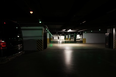 Dark parking garage with car at night