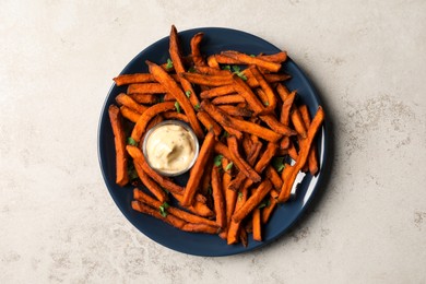 Photo of Delicious sweet potato fries served with sauce on light table