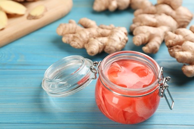 Photo of Spicy pickled ginger and root on light blue wooden table