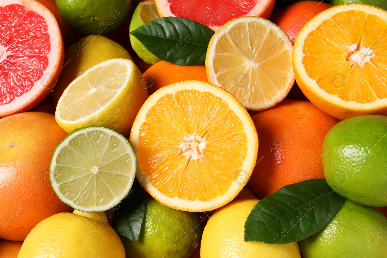 Photo of Different fresh citrus fruits and leaves as background, above view