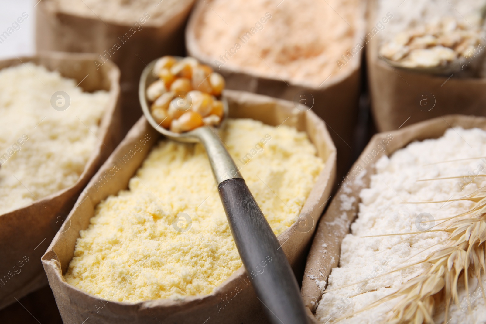 Photo of Paper sacks with different types of flour as background, closeup