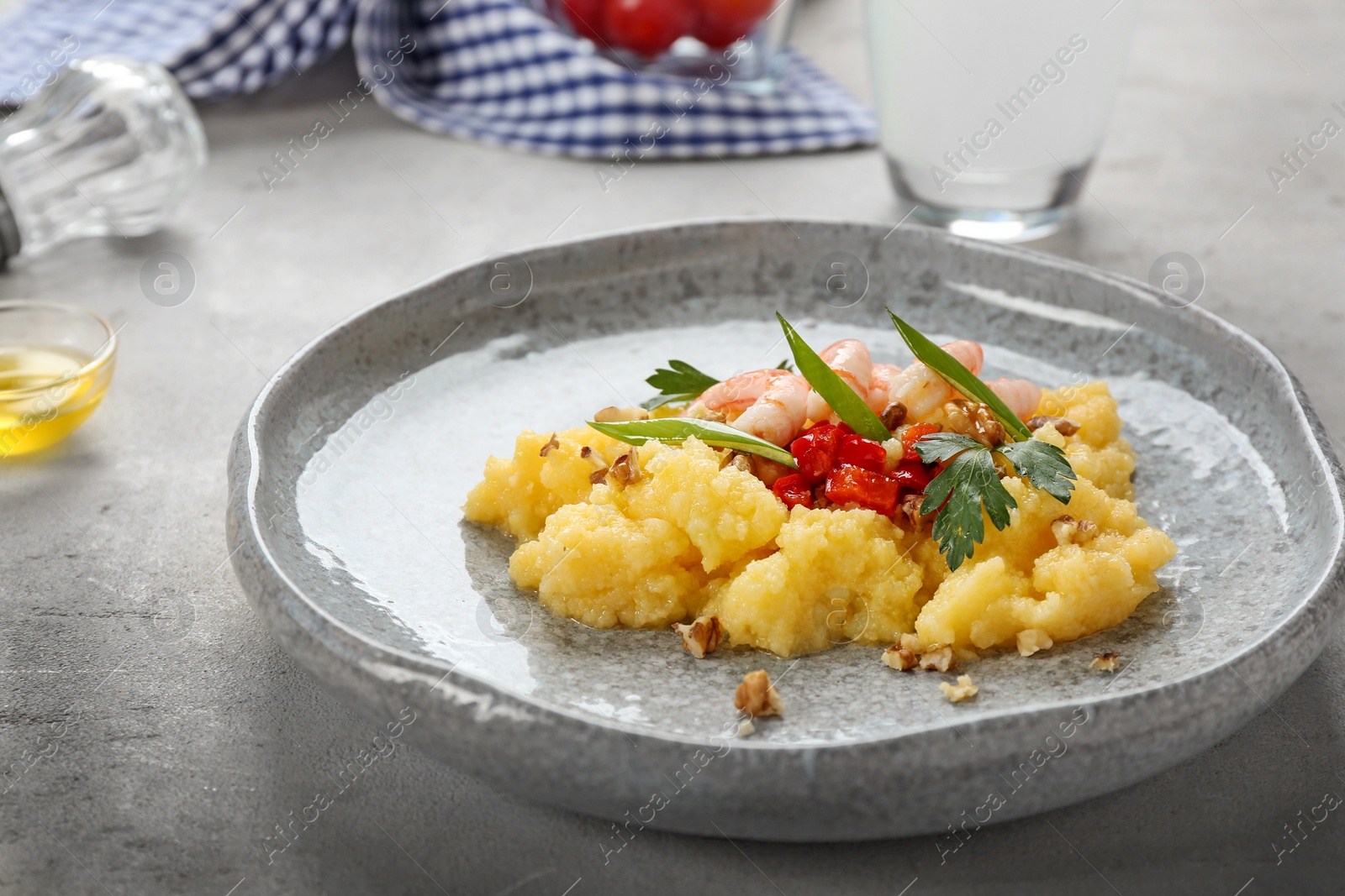 Photo of Plate with fresh tasty shrimp and grits on table