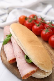 Photo of Delicious sandwich with ham and basil on table, closeup