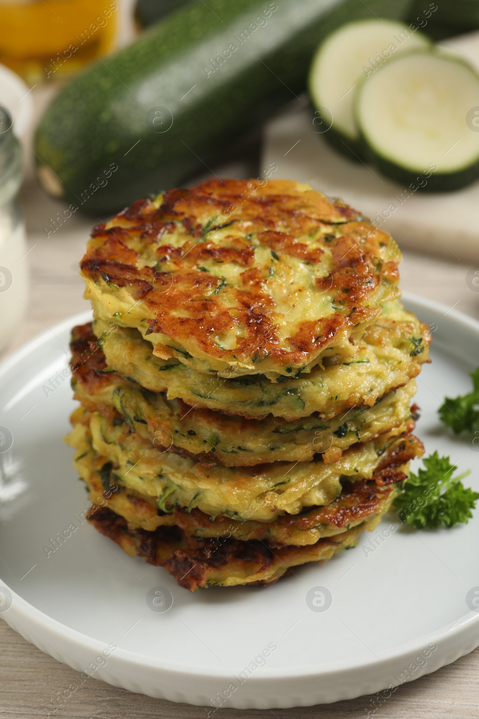 Photo of Delicious zucchini fritters served on wooden table, closeup