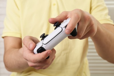 Photo of Man using wireless game controller indoors, closeup