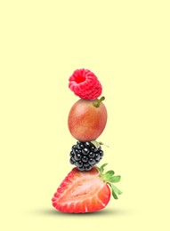 Image of Stack of different fresh tasty berries on honeydew color background