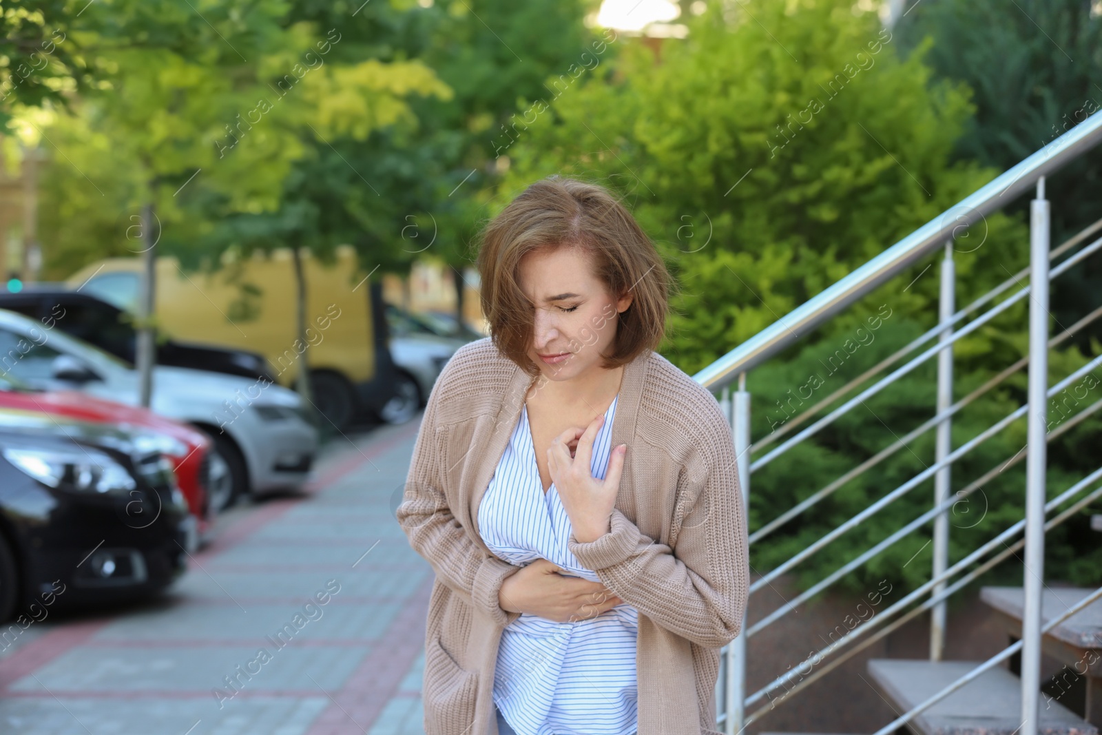 Photo of Mature woman having heart attack, outdoors