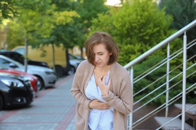 Photo of Mature woman having heart attack, outdoors