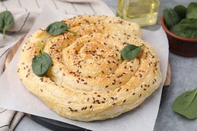 Photo of Delicious puff pastry with spinach on grey table, closeup